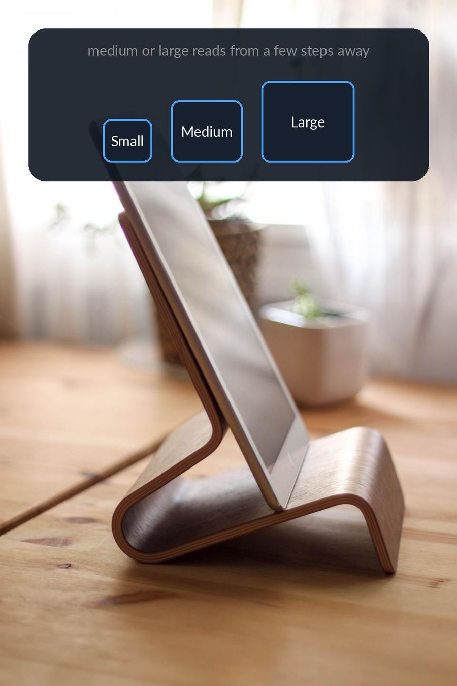 An iPad on a wooden stand with the app's Small, Medium and Large widget sizes drawn above it