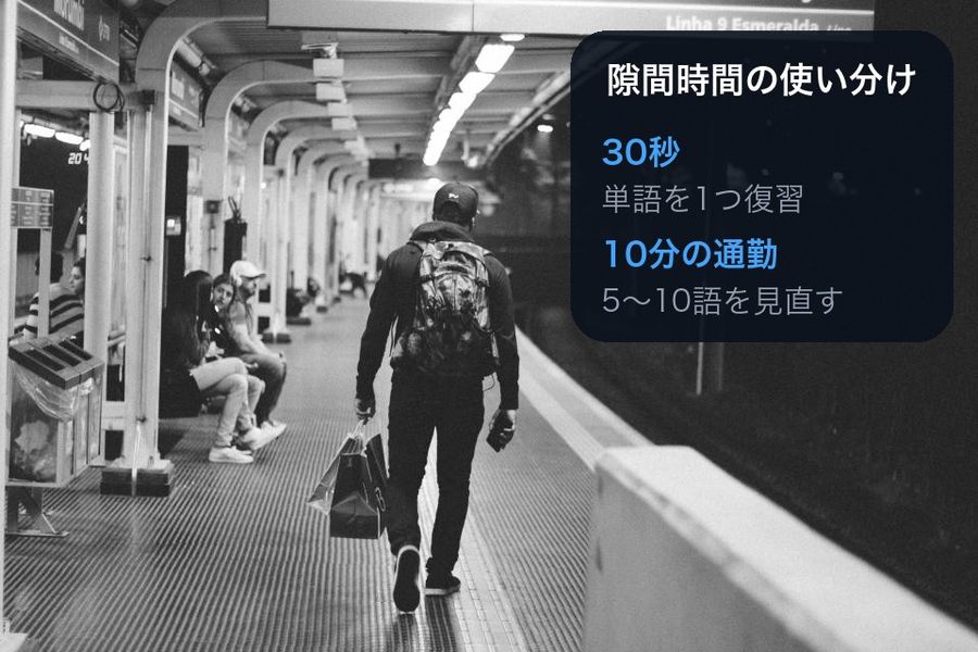 The dark half of a subway-platform photo with a panel reading '隙間時間の使い分け' (how to use spare time): a 30-second gap means reviewing one word, a 10-minute commute means reviewing 5-10 words