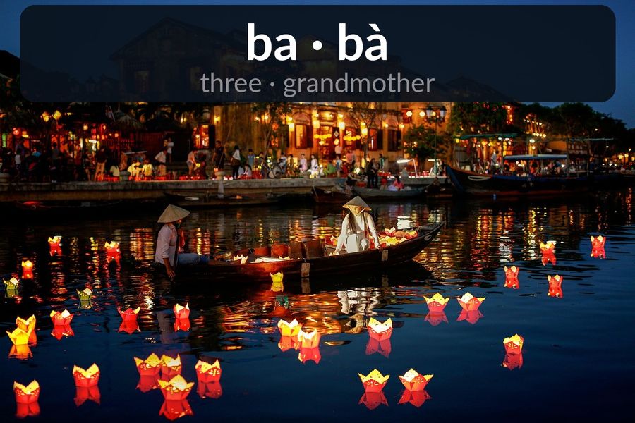 Hoi An's lantern-lit river at night with the Vietnamese minimal pair ba (three) and bà (grandmother), differing by one tone mark