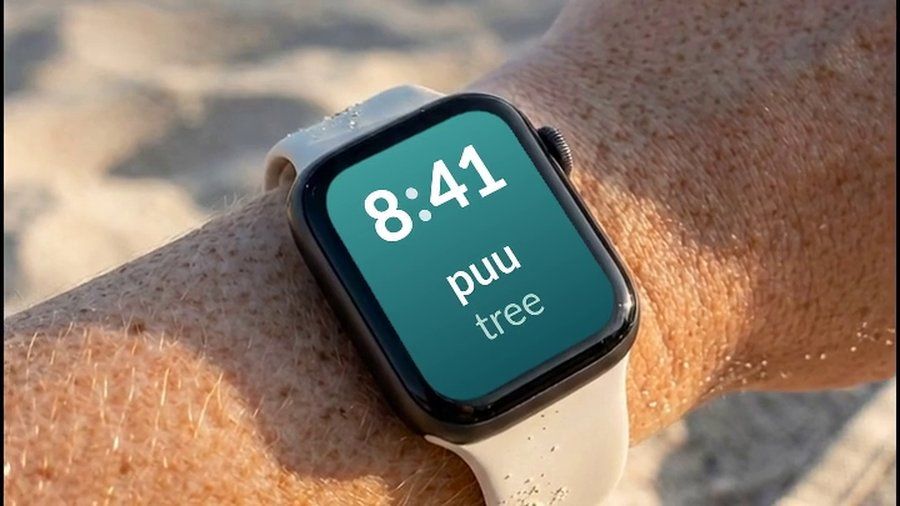 An Apple Watch on a beach, showing a Finnish word and its English translation on the watch face