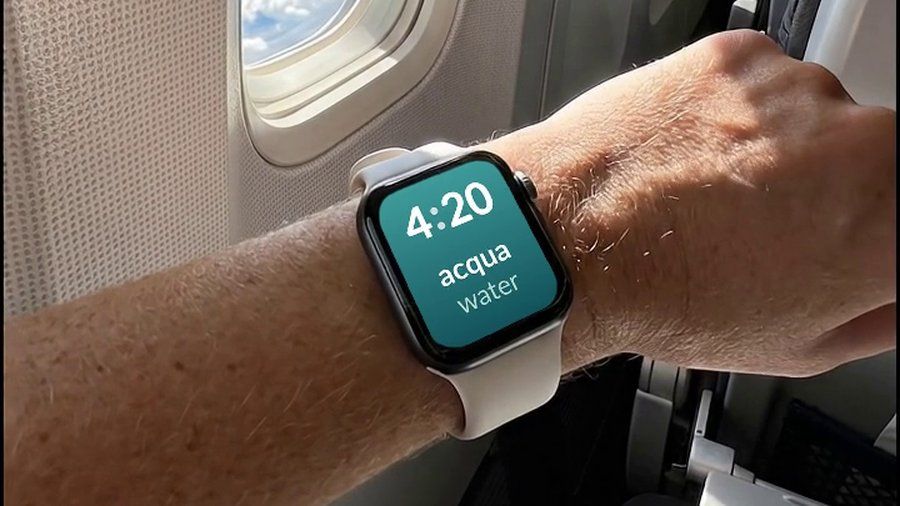 An Apple Watch on a plane, showing a Italian word and its English translation on the watch face