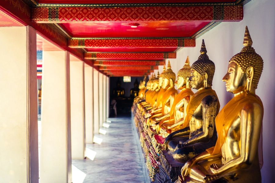 A row of golden Buddha statues in a Bangkok temple