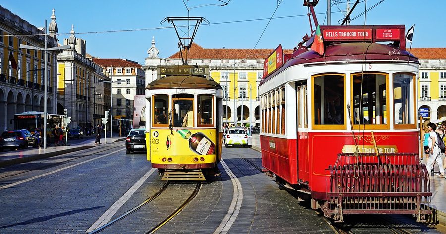 Yellow and red trams on a street in Lisbon